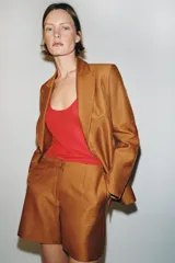 Blazer entallado color tostado confeccionado con lino. Cuenta con cuello solapa, manga larga con hombreras y cierre frontal con dos botones forrados a tono. Presenta forrería interior blanca.