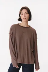 Remera de manga larga con corte oversized, color azul marino con cuello redondo en contraste color marrón. Presenta costuras decorativas a contratono hechas a mano en la zona de los hombros y logo bordado en el centro del pecho.