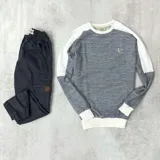 Buzo gris con mangas ranglan blancas y logo bordado en el pecho.