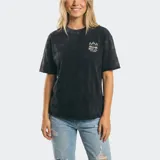 Remera oversize de manga corta color negro con efecto acid wash y estampa pequeña en el pecho con diseño de palmeras y logo de la marca.