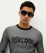 Suéter de punto con diseño de rayas verticales, cuello redondo y manga larga. Presenta un estampado con la palabra 'Rebellion' en el pecho.