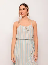 Top de algodón con estampado de rayas verticales en celeste y blanco con finas líneas ocre. Posee tirantes finos regulables y un detalle anudado en el escote.