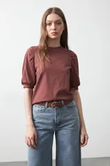 Remera de algodón color ladrillo, de manga corta con detalle levemente abullonado en los hombros y calce cómodo.