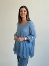 Sweater de punto color azul jean, con cuello redondo, mangas largas con vuelta y diseño amplio de corte evasé.