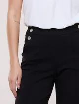 Pantalón crop blanco de corte recto con cintura ancha y botones decorativos laterales. Cuenta con bolsillos y pinzas frontales.