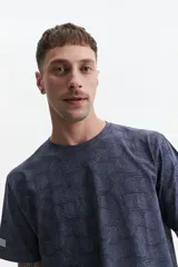 Remera verde militar con estampado de hojas en tono más oscuro, de manga corta, cuello redondo y corte regular.