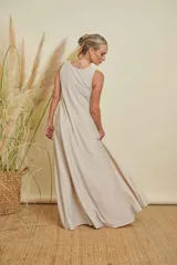 Vestido largo color beige claro, sin mangas y con cuello redondo.