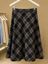 Falda midi con diseño a cuadros en tonos azul, negro y mostaza, de corte evasé y caída fluida.