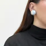 Aros de clip con diseño esférico de acabado metálico plateado y superficie lisa con efecto espejo.