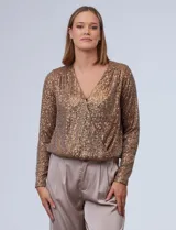 Blusa Ninety de microtul bordado con lentejuelas color dorado. Escote en V cruzado, ruedo elastizado y forro interno a tono.