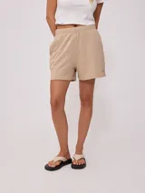 Short de tiro alto confeccionado en tejido de algodón y poliéster, con cintura elástica y bordado pequeño en la parte inferior.