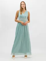 Vestido largo de gasa con hilo metalizado lurex, color beige, con escote en V cruzado y drapeado, cintura alta con aplicaciones de strass y falda larga plisada con movimiento.