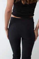 Pantalón recto cropped de tiro medio y fit slim color verde militar, confeccionado en tejido elástico, con cierre frontal oculto y sin bolsillos visibles.