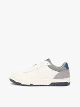 Zapatillas de baloncesto Tommy Hilfiger de corte bajo, color blanco con detalles en gris, azul y suela bitonal. Presentan exterior de piel con paneles de ante y mezcla de texturas, cordones blancos y detalles distintivos de la marca.