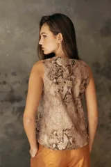 Musculosa de gabardina con estampado de piel de serpiente, cuello redondo y diseño estructurado con abertura en la espalda y ruedo irregular.