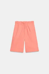 Bermuda color salmón de tiro medio, con cintura elástica ajustable mediante cordón y bolsillos laterales ocultos en costura.
