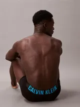 Pack de tres bóxers tipo trunk de Calvin Klein, color negro. La cinturilla elástica distintiva presenta el logo de la marca en tres colores: azul cian, blanco y blanco.