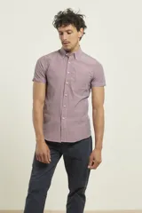 Camisa manga corta con cuello abotonado y estampado a cuadros pequeños en tonos rojo y blanco.