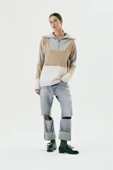 Sweater de lana color beige, gris y blanco, con cuello alto con cierre y detalles de crochet.