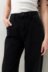 Pantalón de jean azul oscuro, de tiro alto y corte amplio con pinzas centrales.