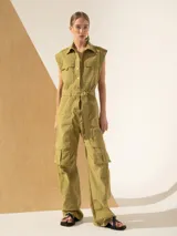 Mono color verde oliva, con cuello camisero, sin mangas, bolsillos frontales y laterales tipo cargo, y cinturón de lazo.