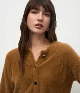 Cardigan de tricot con textura efecto peluche, color negro, de calce regular, escote redondeado y cierre frontal con botones.