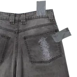 Bermuda baggy de jean color gris lavado, con corte holgado y diseño pintado a mano de un perro con cresta roja en la pierna derecha.