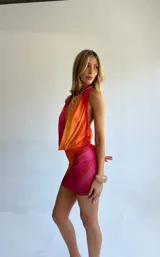 Minivestido con estampado degradado en tonos naranja y fucsia, escote halter y espalda descubierta.