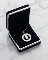Collar de plata 925 con cadena fina y dije circular que presenta un diseño calado de una niña sobre una base de nácar.