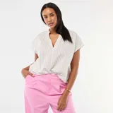 Blusa de manga corta con cuello en V y diseño a rayas verticales finas. Presenta un corte holgado y fluido.