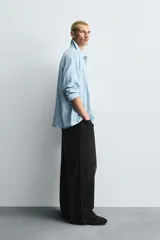 Jeans de denim de algodón, color azul oscuro con efecto lavado. Presentan un corte muy holgado (baggy fit) en toda la pierna y tiro medio. Tienen cinco bolsillos y cierre frontal con cremallera y botón.