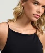 Blusa femenina sin mangas, confeccionada en tejido de algodón con elastano. Presenta un diseño ajustado al cuerpo con escote halter y tirantes finos elásticos.