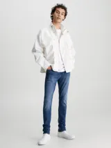 Jeans de mezclilla elástica de algodón, color azul medio con efecto desgastado y lavado. Presentan un corte skinny fit, cintura de talle bajo, bragueta con cremallera y estilo de 5 bolsillos.