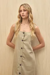 Vestido largo sin mangas color marrón, con escote cuadrado y abotonadura frontal completa. Corte recto con leve abertura en el ruedo.