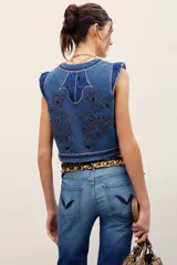 Chaleco de denim azul de corte ajustado, con cuello en V y elaborados bordados decorativos en contraste.