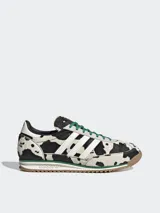 Championes Adidas Originals SL 72 OG con estampado de vaca en blanco y negro, con las tres tiras blancas y cordones verdes.