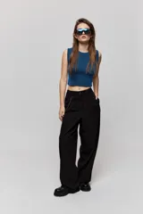 Top de textura acanalada y calce al cuerpo, sin mangas, con cuello redondo y diseño de espalda abierta con lazo para anudar.
