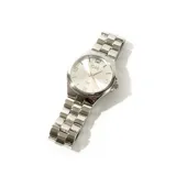 Reloj de pulsera G&B modelo Grecia, fabricado en metal plateado con esfera redonda blanca y números análogos.
