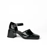 Zapato de cuero vacuno color gris topo, con talón descubierto y pulsera con hebilla. Tiene taco de madera forrado en cuero y suela de goma. La horma es de punta cuadrada, ancha y cómoda.