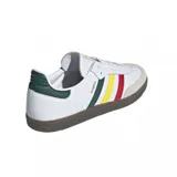 Championes Adidas Samba OG blancos con las tres tiras características de la marca en verde, amarillo y rojo. La puntera es de gamuza color gris claro y la suela es de goma color caramelo. El contrafuerte es de cuero verde.