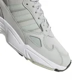 Championes adidas Falcon W de estilo urbano, con diseño retro inspirado en los años 90. Presentan una combinación de tonos gris claro y detalles en verde menta, con una suela robusta de goma blanca y entresuela de EVA para mayor amortiguación.