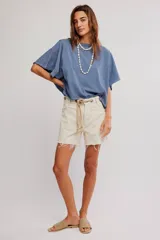Remera de jersey de algodón blanca con silueta murciélago, escote barco y mangas dolman muy anchas de corte recto y holgado.