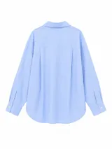 Camisa de corte oversize con estampado de rayas verticales en tonos azul, blanco y rojo. Presenta cuello clásico, cierre frontal con botones y mangas largas con puños abotonados.