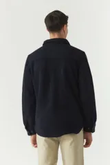 Chaqueta azul marino de paño con cuello clásico, cierre frontal con botones, dos bolsillos de parche en el pecho con solapa abotonada y bolsillos laterales.