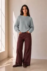 Buzo de tejido de punto celeste, con cuello redondo, mangas largas y diseño holgado.