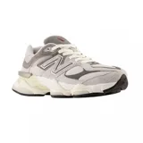 Championes urbanos New Balance modelo 9060, con diseño robusto y futurista en tonos grises, blancos y crema. Presentan una combinación de malla y gamuza, con el logo N característico en los laterales y una suela voluminosa con tecnología de amortiguación.