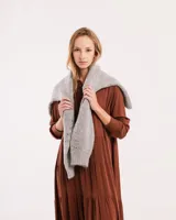 Vestido largo color marrón con cuello camisero, manga larga con puños elásticos y falda escalonada con volados.