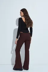 Pantalón de corte oxford, color negro, con ajuste en la cadera y pierna acampanada hacia el bajo. Presenta una silueta fluida y entallada.