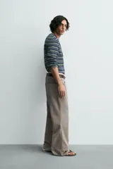 Pantalón de pana de corte flare, color verde oliva desgastado, con cinco bolsillos y cierre frontal de cremallera y botón.