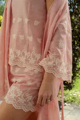 Conjunto de pijama compuesto por una musculosa de escote redondo y un short con elástico en la cintura. Ambas piezas están confeccionadas en tela a rayas finas con detalles bordados florales y terminaciones con puntilla festoneada.